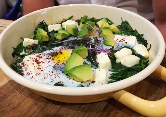  "Green Shakshuka" Warm eggs cooked over a bed of garlicky spinach, leeks, and greens with tangy feta cheese, served with homemade wholemeal pita