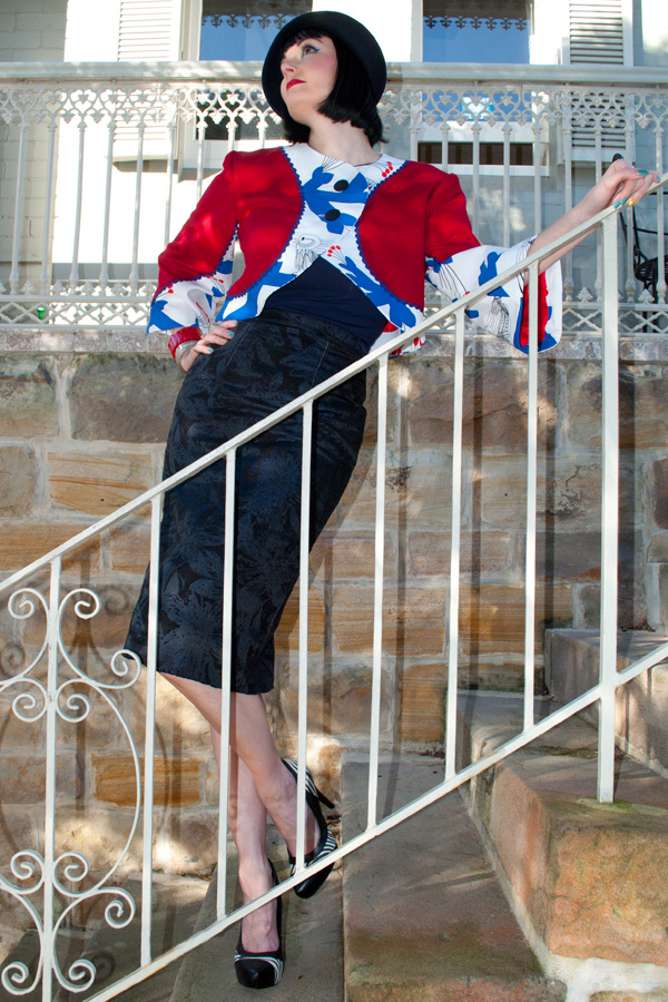 Lucy wears a one of a kind bolero, handmade from a red wool, and a blue bird printed cotton.