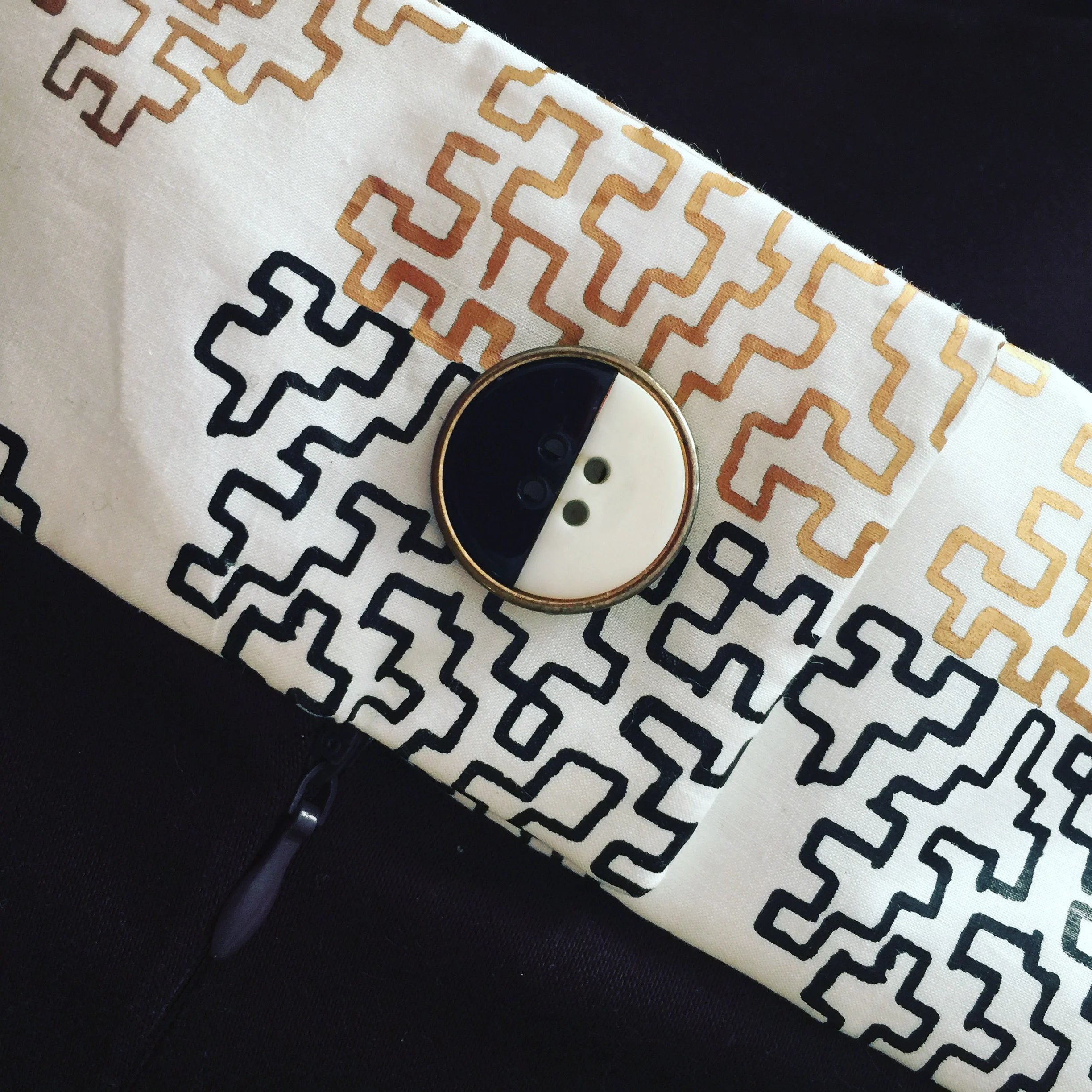 Detail of the vintage button on the Brown, Gold and Black Pleated Skirt.