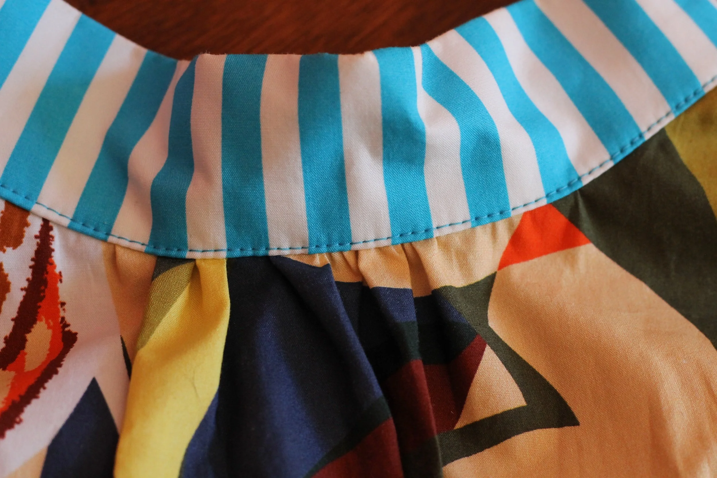 A handmade, bright coloured, sleeveless cotton blouse. Made in Sydney Australia by Penelope RED