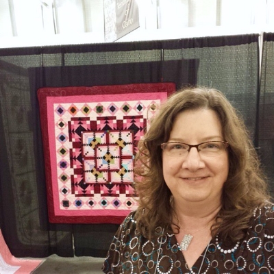 Vicki with her quilt at AQS Grand Rapids in 2013 (this photo is from her son's instagram and was taken the weekend he went to college. Isn't that darling??)