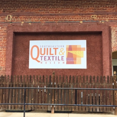 First, I love their logo. Second, I want a rod installed on this wall so I can hang quilts and take pictures of them!