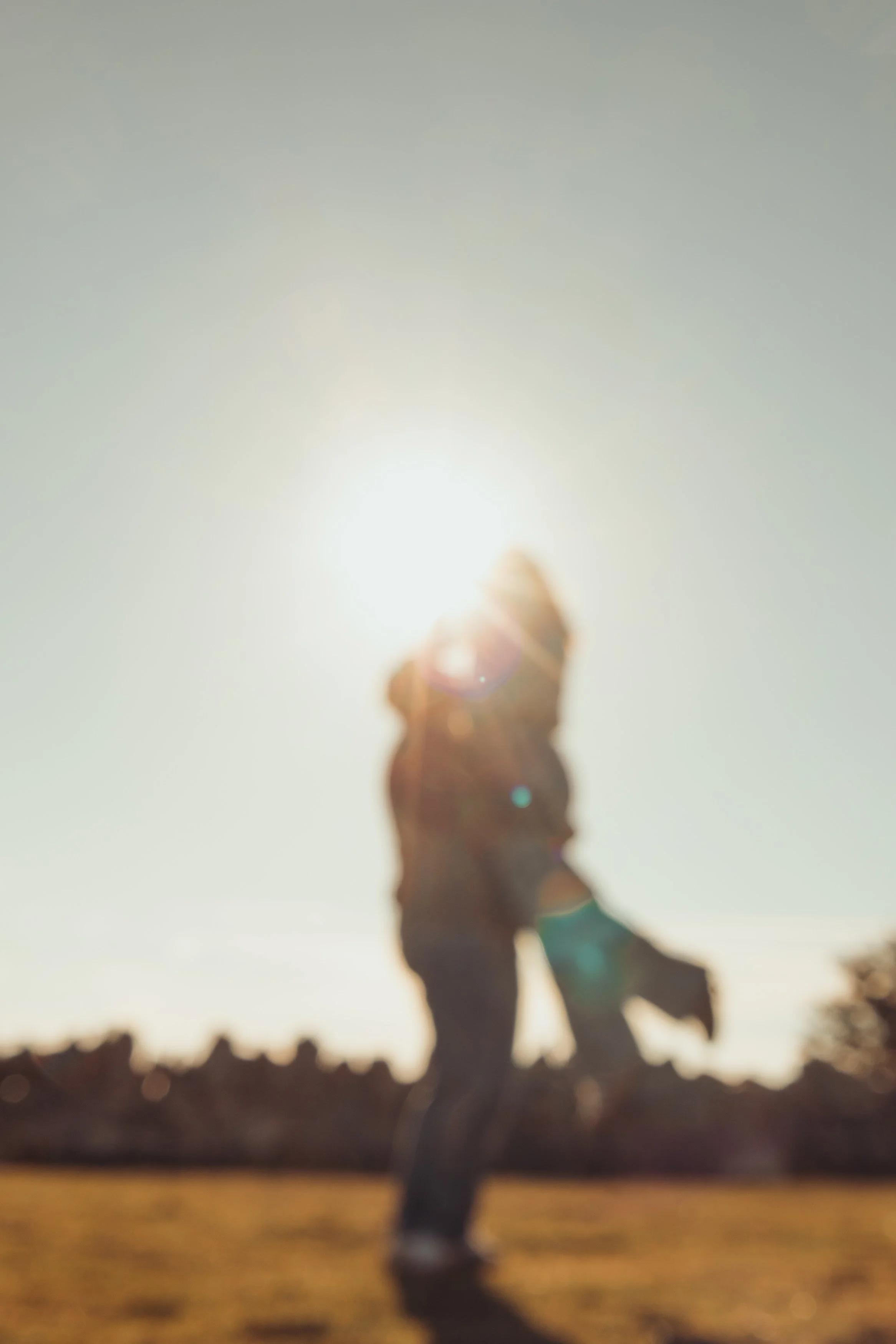 Silhouette d'une personne tenant la main d'un enfant, fond lumineux du soleil