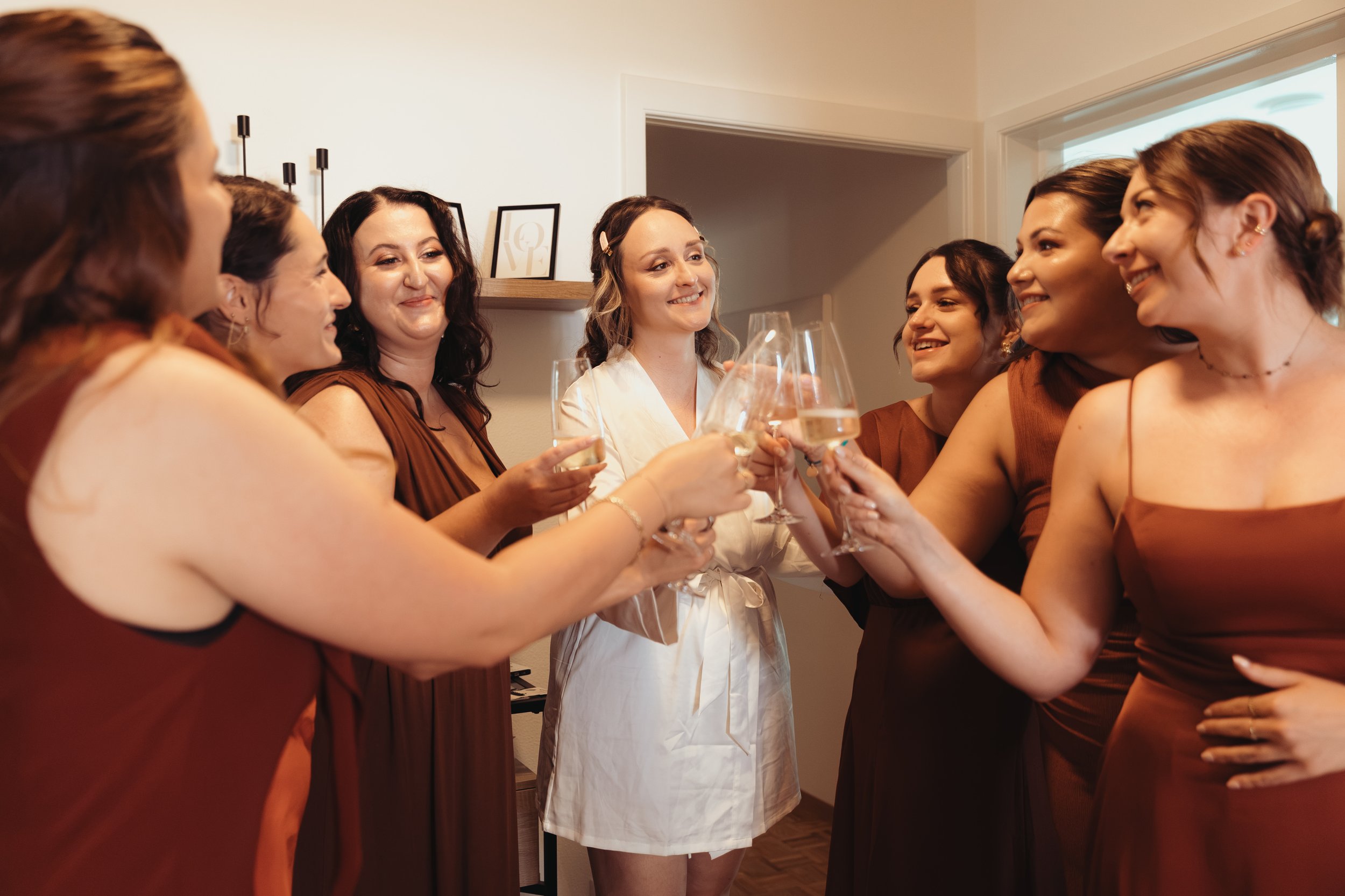 Groupe de femmes célébrant avec des flûtes de champagne dans une pièce lumineuse.