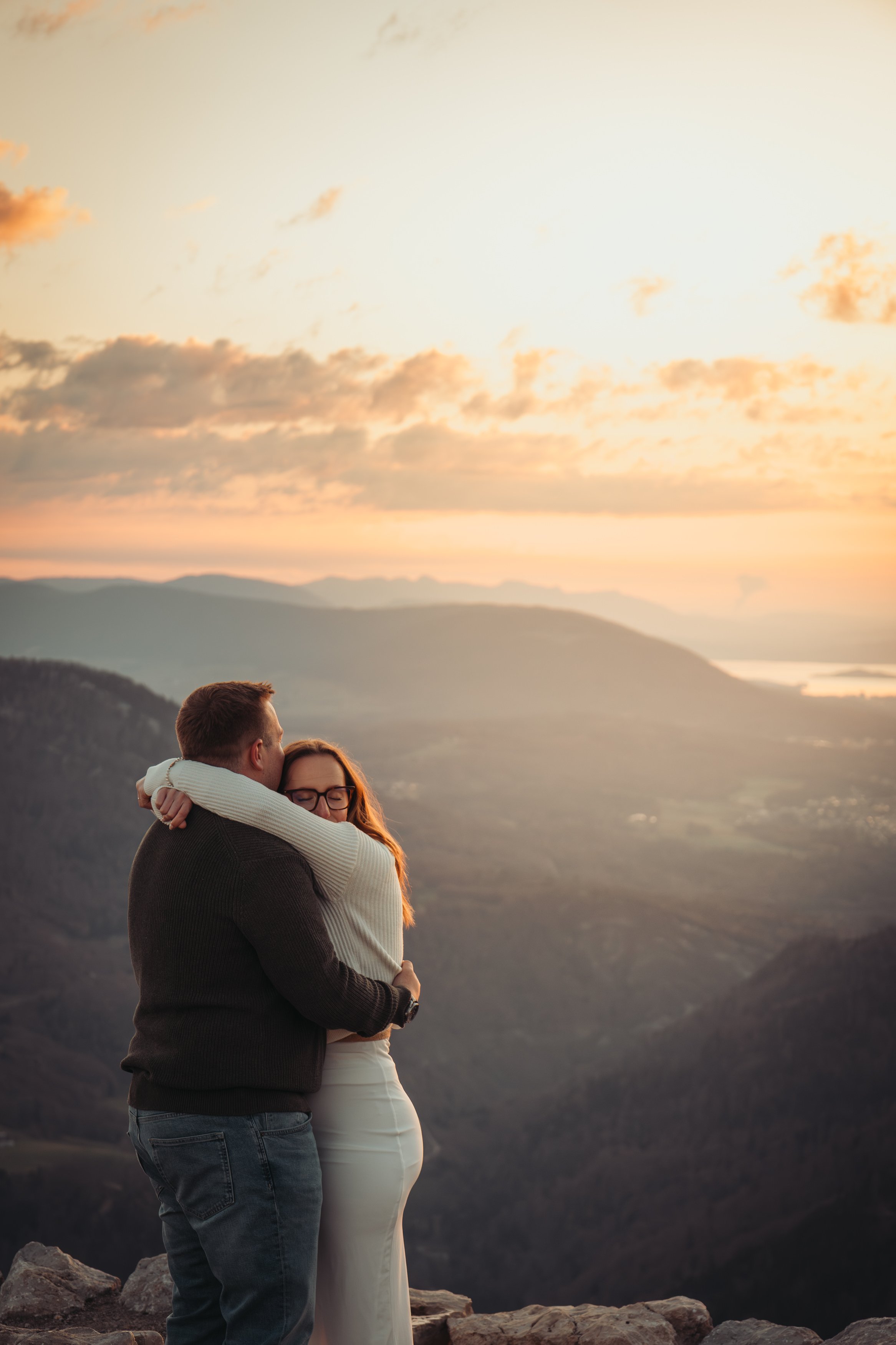 Un couple enroulé dans une étreinte dans une région montagneuse au coucher du soleil