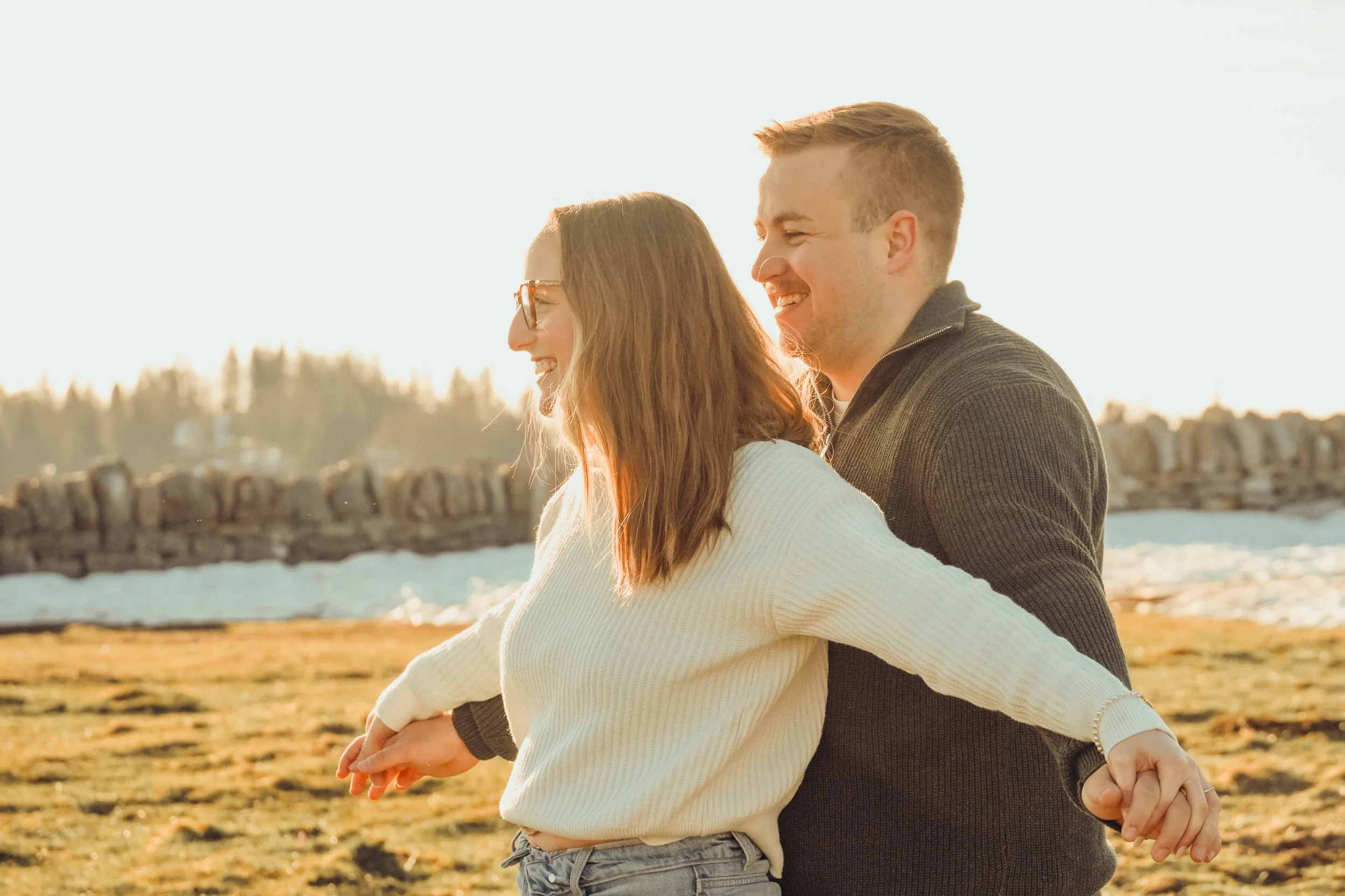 Deux personnes, un homme et une femme, marchent main dans la main dans un paysage en plein air par une journée ensoleillée.