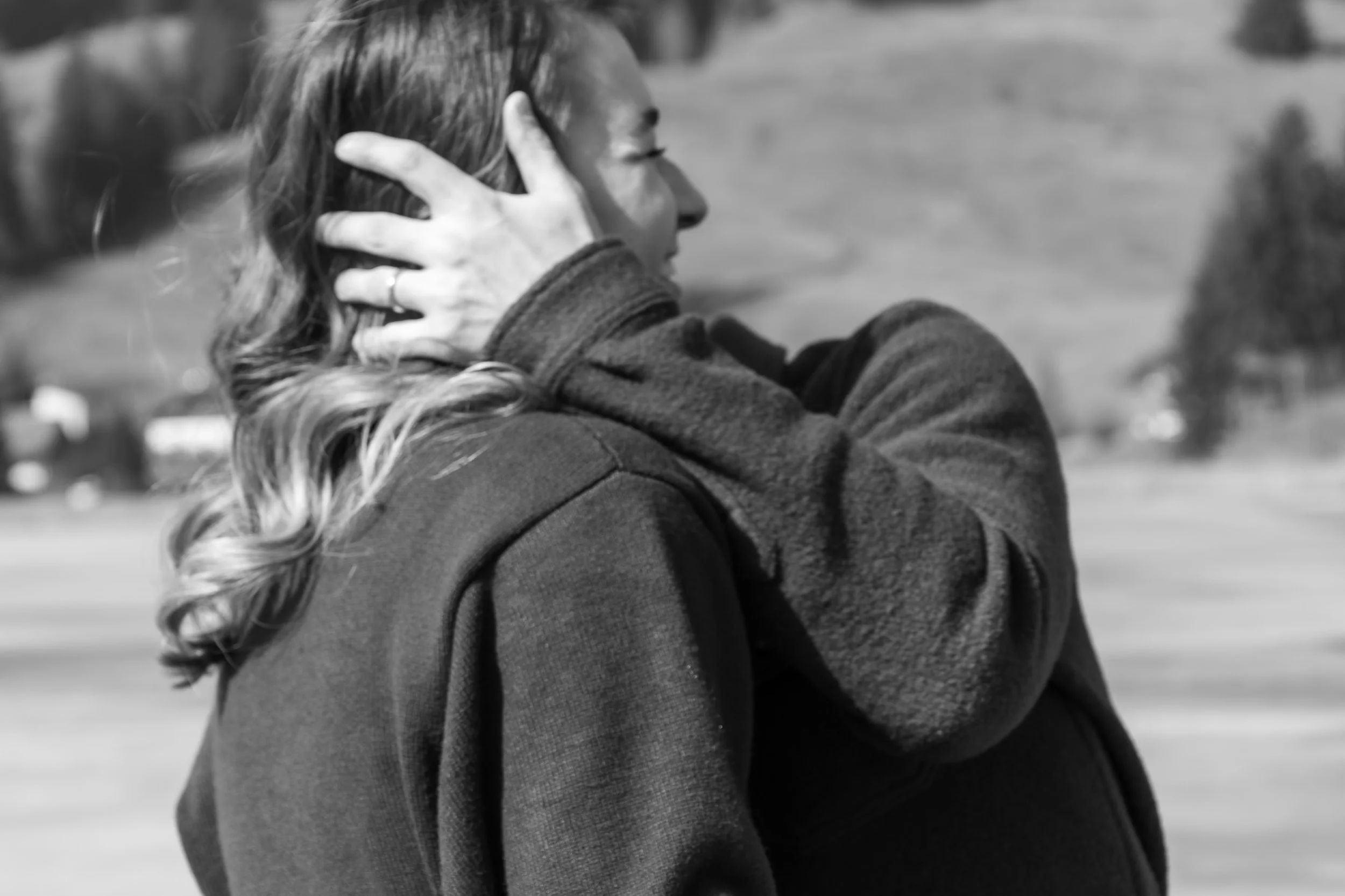 Une personne, vue de profil, tenant sa tête avec une main. La personne a des cheveux longs et porte un manteau ou une veste.