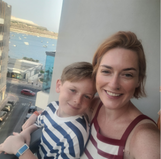 Photo of Holli Moon with strawberry blond bob smiling with a child in front of her