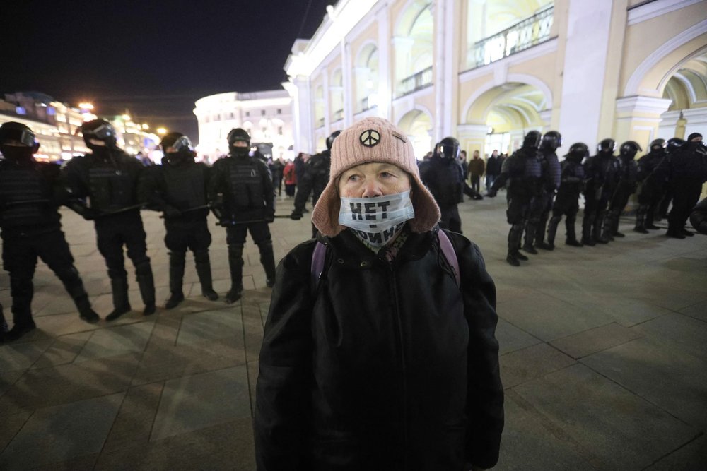  A demonstrator wearing a face mask with an inscription reading "No to war" stands in front of a line of police officers during a protest against Russia's invasion of Ukraine in central Saint Petersburg on Feb. 27, 2022. [ Article. ]  SERGEI MIKHAILI