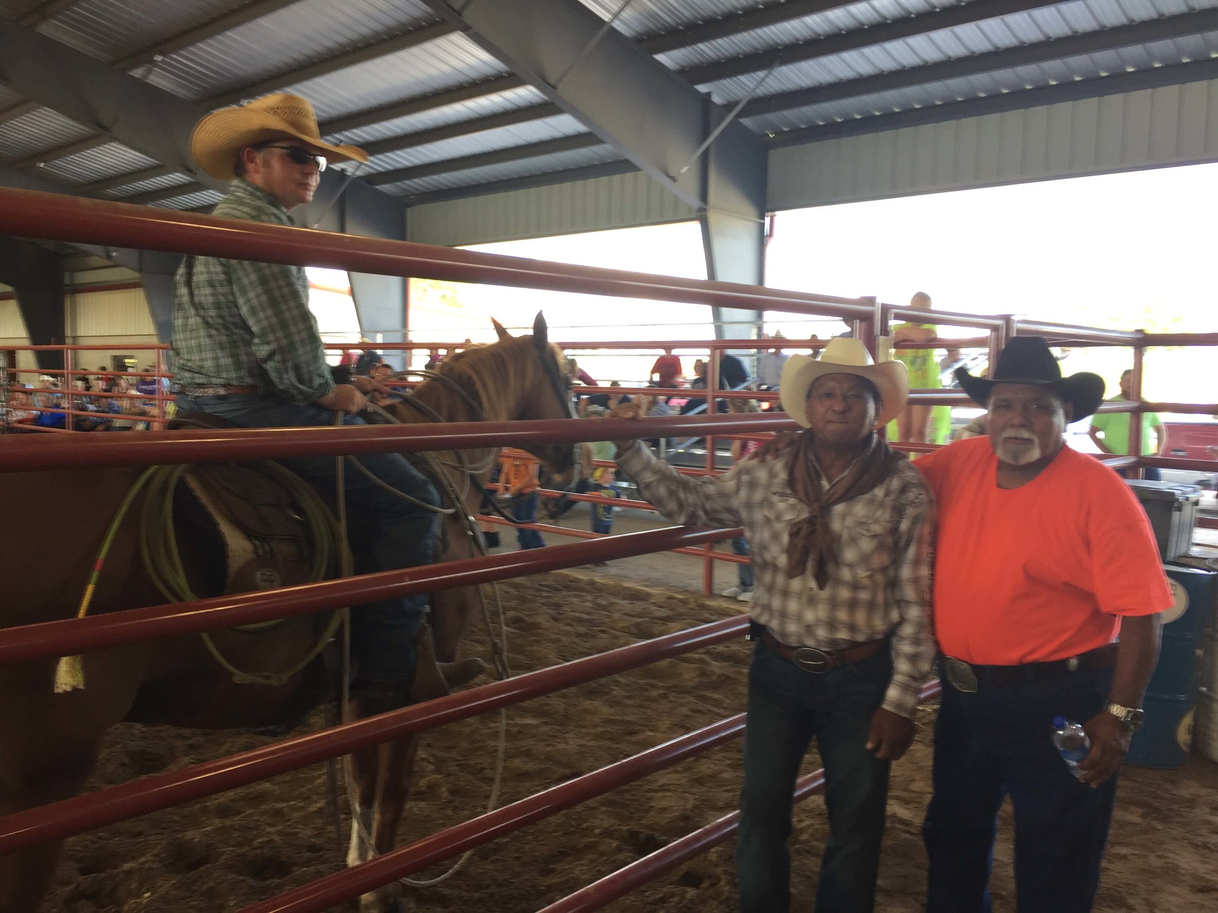 Frank Milano (orange shirt) and Alfredo Andrade (of Honduras) talk with Nick Gas (cowboy pastor and horse trainer) in a break in the action at the Denton County bull riding event put on in honor of Alfredo's son, Sergio, who was a professional bull rider and friend of ours who was murdered a couple of years ago.