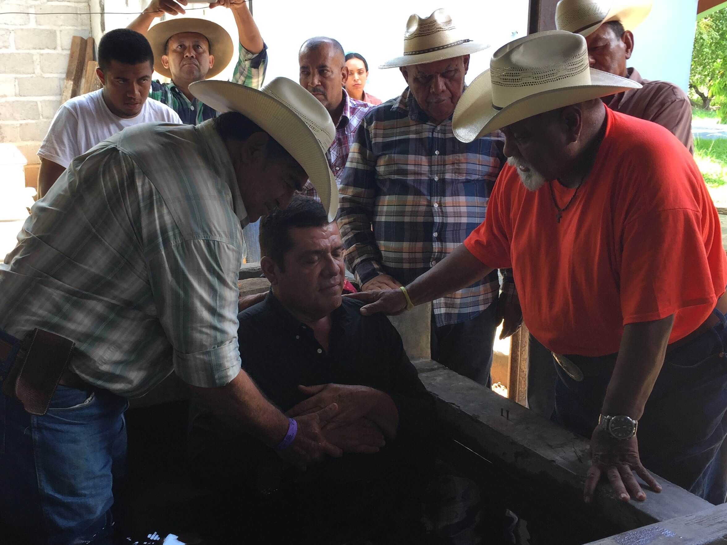 Frank says a few words before he and Cesar baptize Carlos. Looking on in the hat is Jose Matute. 