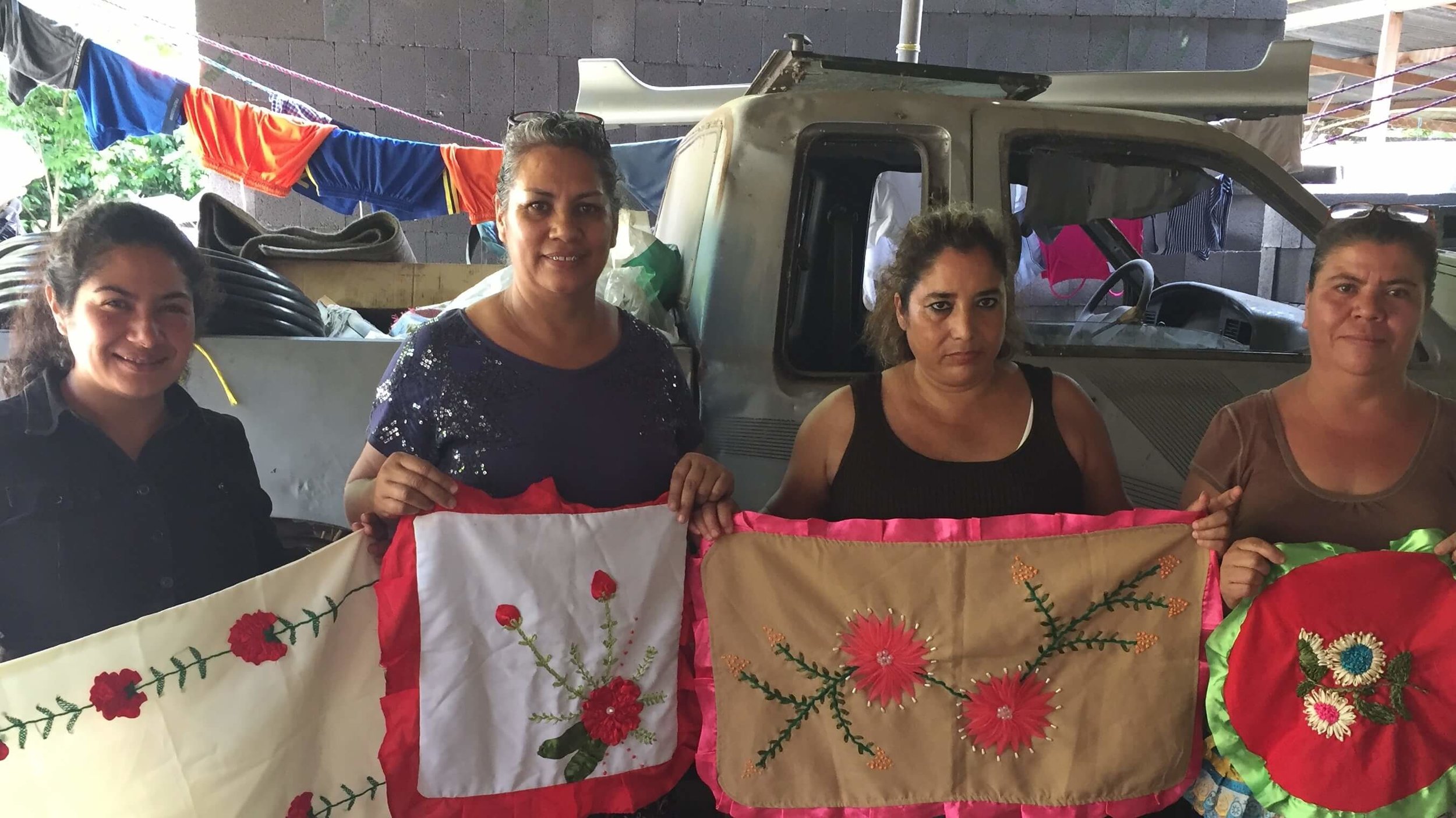 The leadership team for a women's micro-business group in San Jose Acatempa, Guatemala, shows samples of the work of one of the ladies. Irma, the president of the group, is the second lady from the left. 