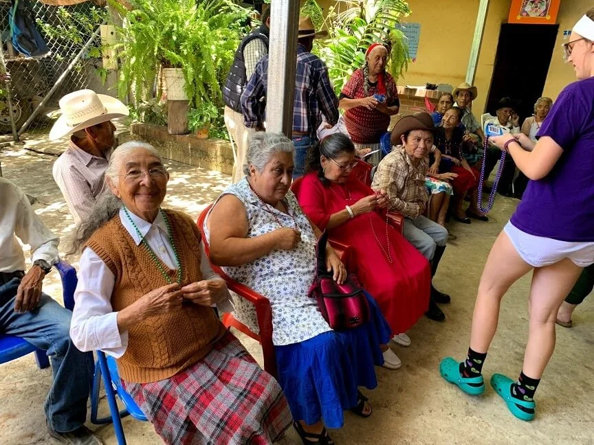 In Santa Cruz, Alex placed bead necklaces around each neck of the senior ladies.