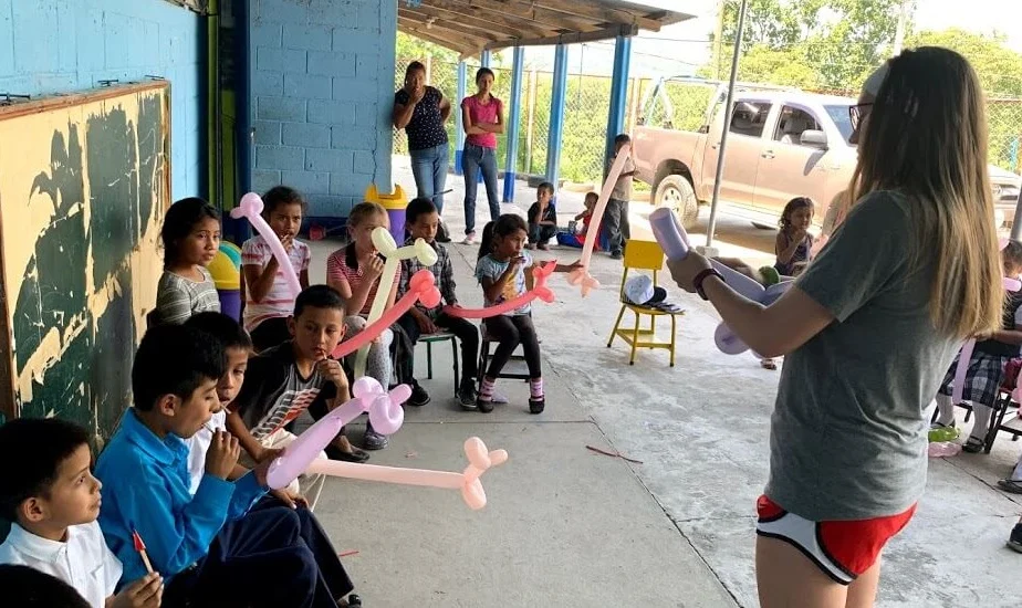 Making balloon figures was a hit at several places. Here, Alex showed some children how to make a dog.