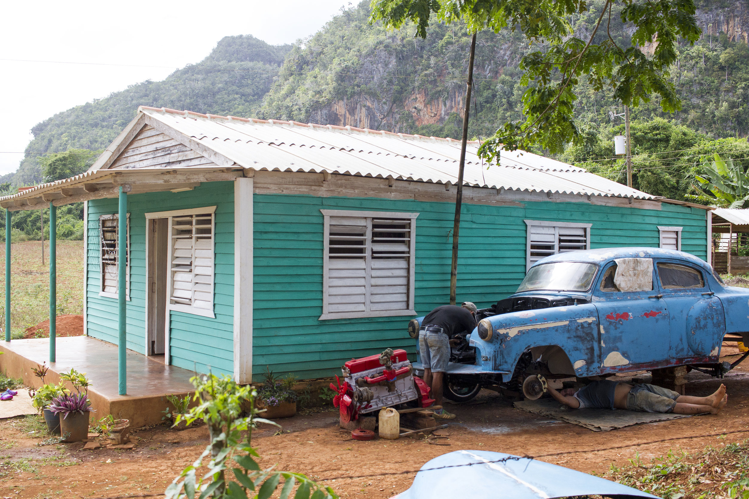 Two men working on a classic car in Viñales