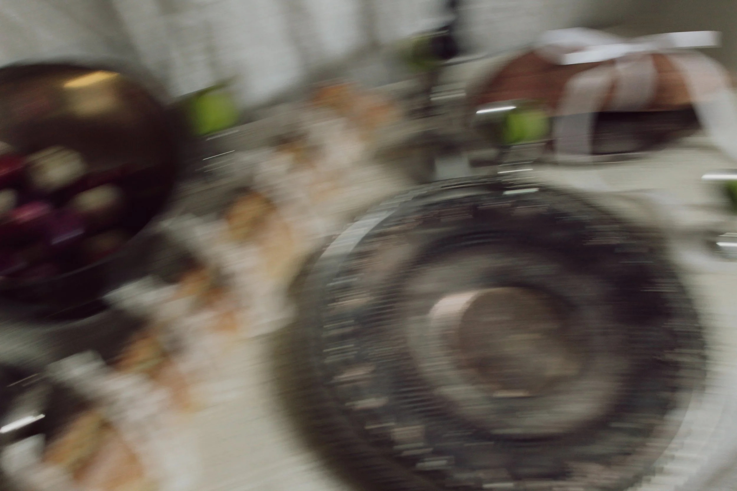 A blurry image of a kitchen countertop with a kettle, a metal bowl with onions, and other kitchen utensils.