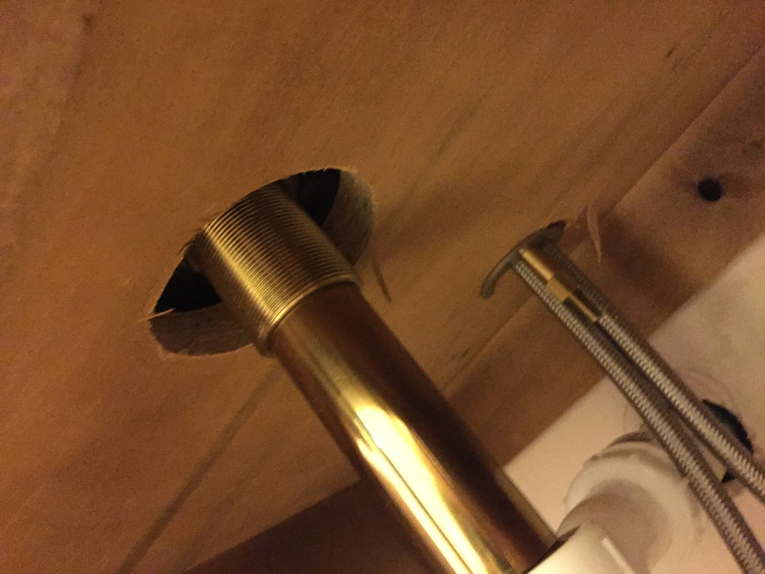 This is a shot of the underside of the vanity top.&nbsp; The hole in the front is where the drain comes thru (look at that beautiful brass!), and the hole behind that is for the faucet.&nbsp; The 2 silver pipes coming down from there are for hot/col…