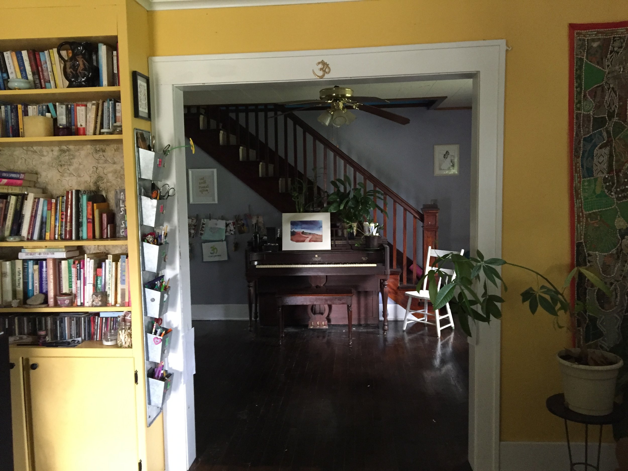 This is the view you see when you first walk into Brooke's home. You're in the living room, which opens up to the dining room, with a totally inviting view of her piano. To the left is a sunny built in bookshelf.
