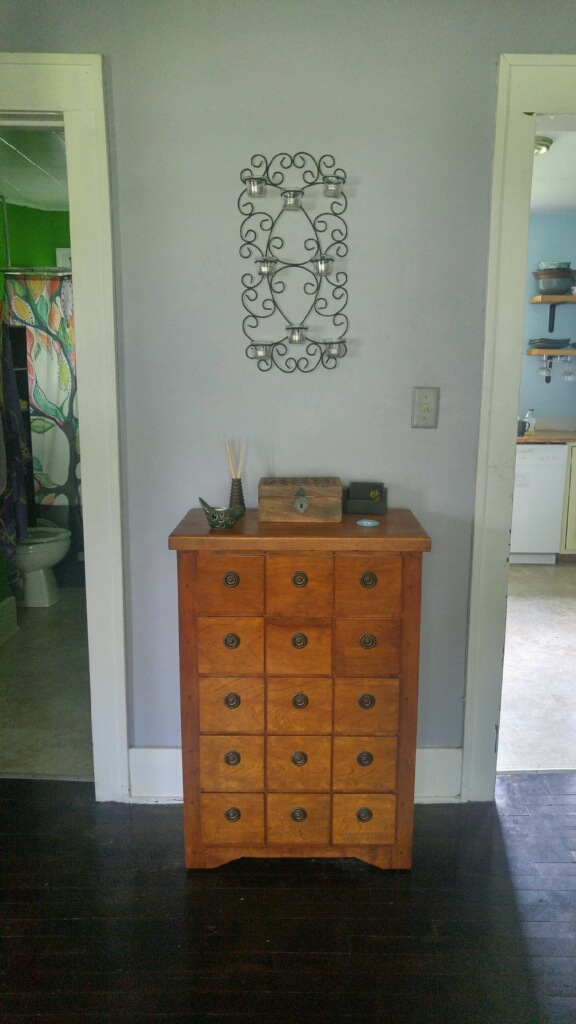 Still in the dining room, there is a great little storage moment outside the kitchen. When I was visiting last time, I had some congestion, so Brooke goes into her little magic box here and pulls out some Thieves oil. A few drops and I'm feeling fine.
