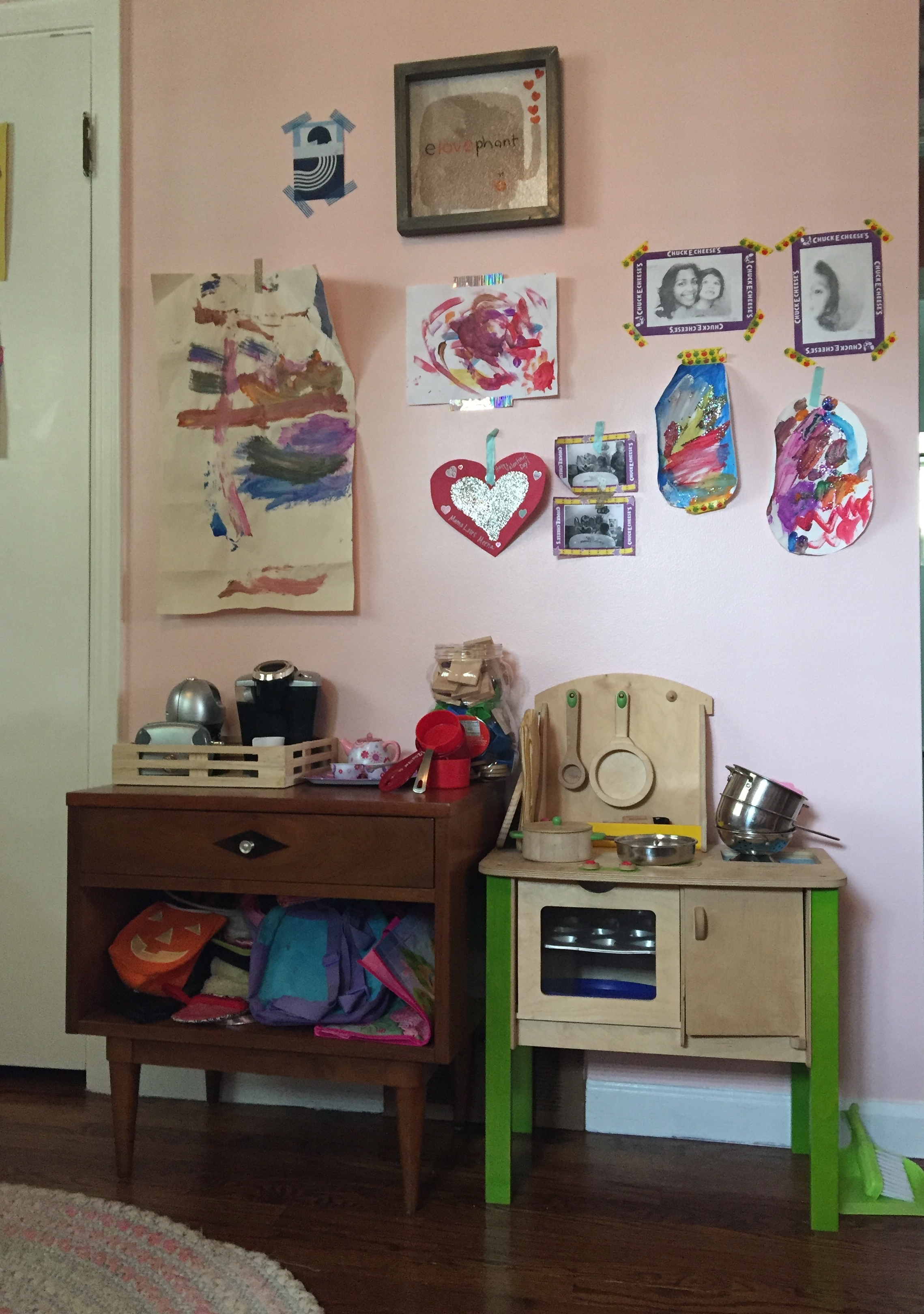 Above the play kitchen is the fancy "gallery wall". This is where we've been adding a lot of Meena's art projects. Other than the framed elephant print, everything is stuck on with washi tape. It doesn't pull of the paint, you can move stuff around, it's cheap, and comes in a bunch of colors and prints. The kids love just grabbing some and sticking their stuff up.