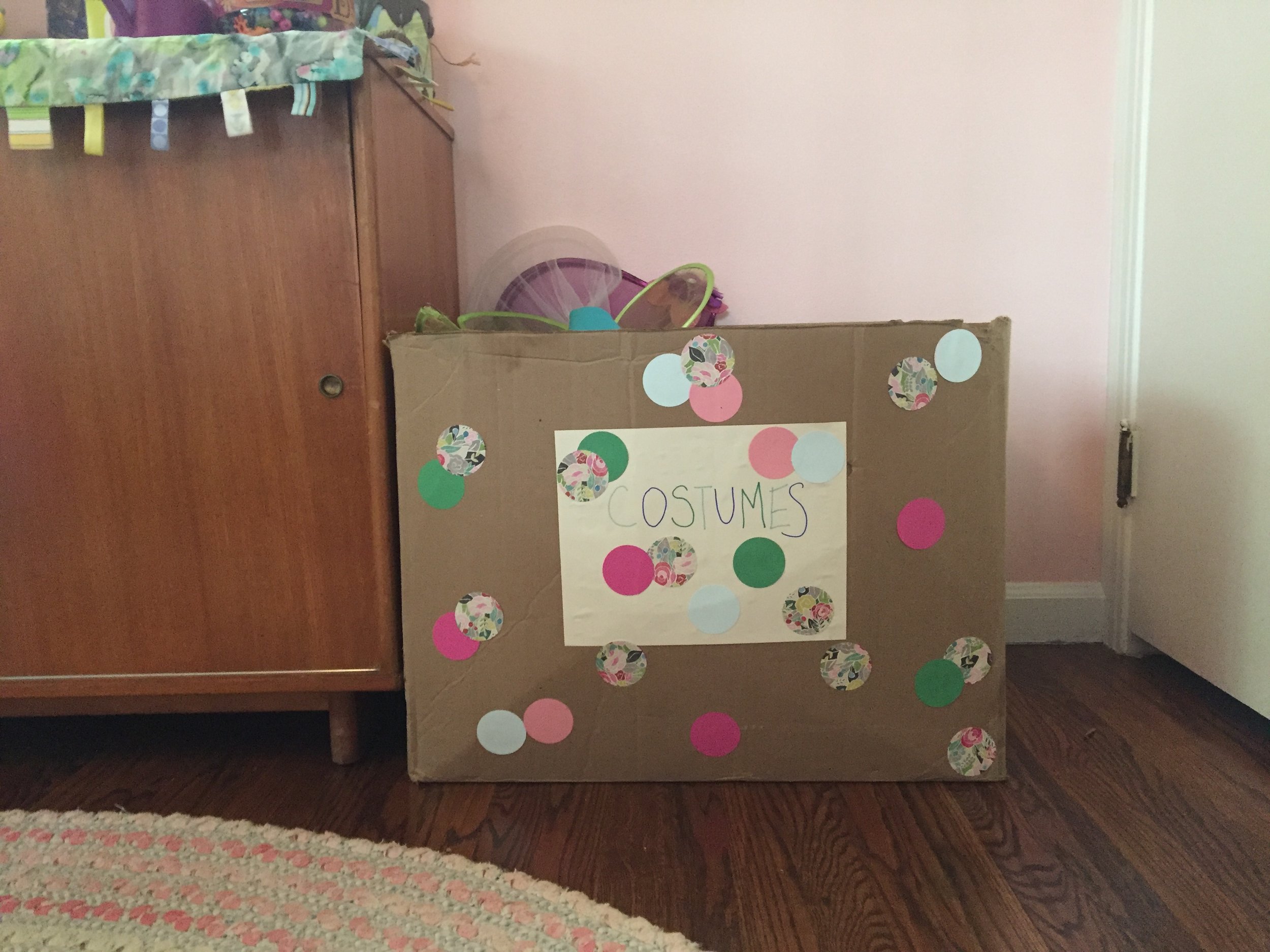 This is a big box of handed down costumes from my SIL. Princess dresses, princess shoes, fairy wings. Meena walks around in this stuff all day. It's so fun. Meena helped me decorate the box. Because who wants to just look at a plain cardboard box?