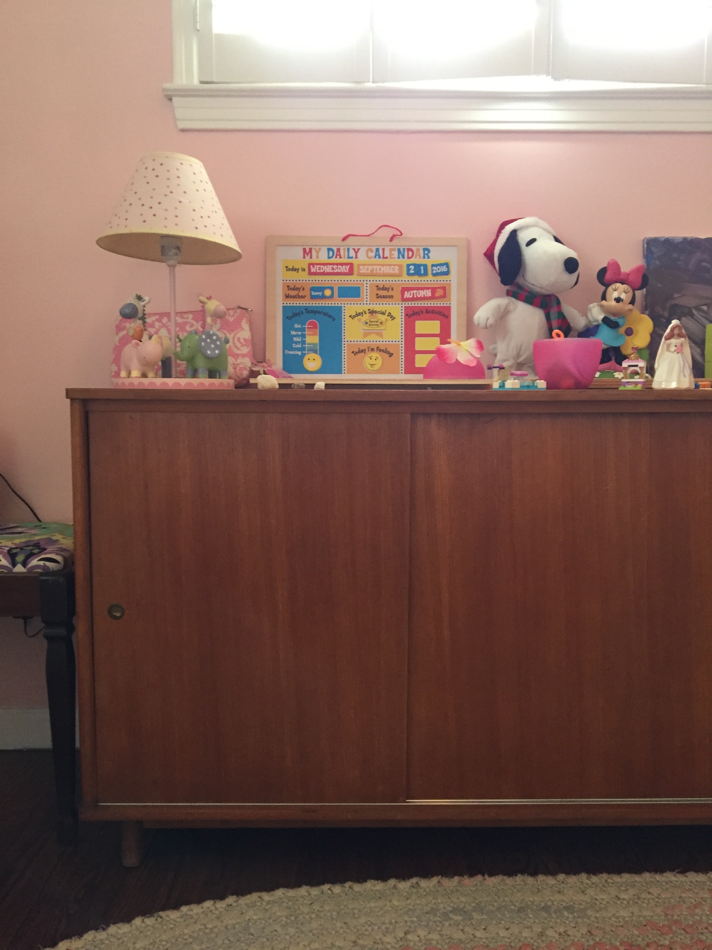 On the wall next to that stool/bench is a vintage teak credenza by Drexel. Everything on top is within reach to Meena, and she only uses the top of the credenza to store more toys and knick/knacks. The inside of the credenza is full of my crafting supplies.