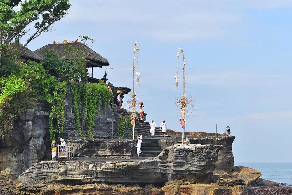 Local worshippers climb the temple steps to present their hand-made offerings to deceased relatives and gods. 