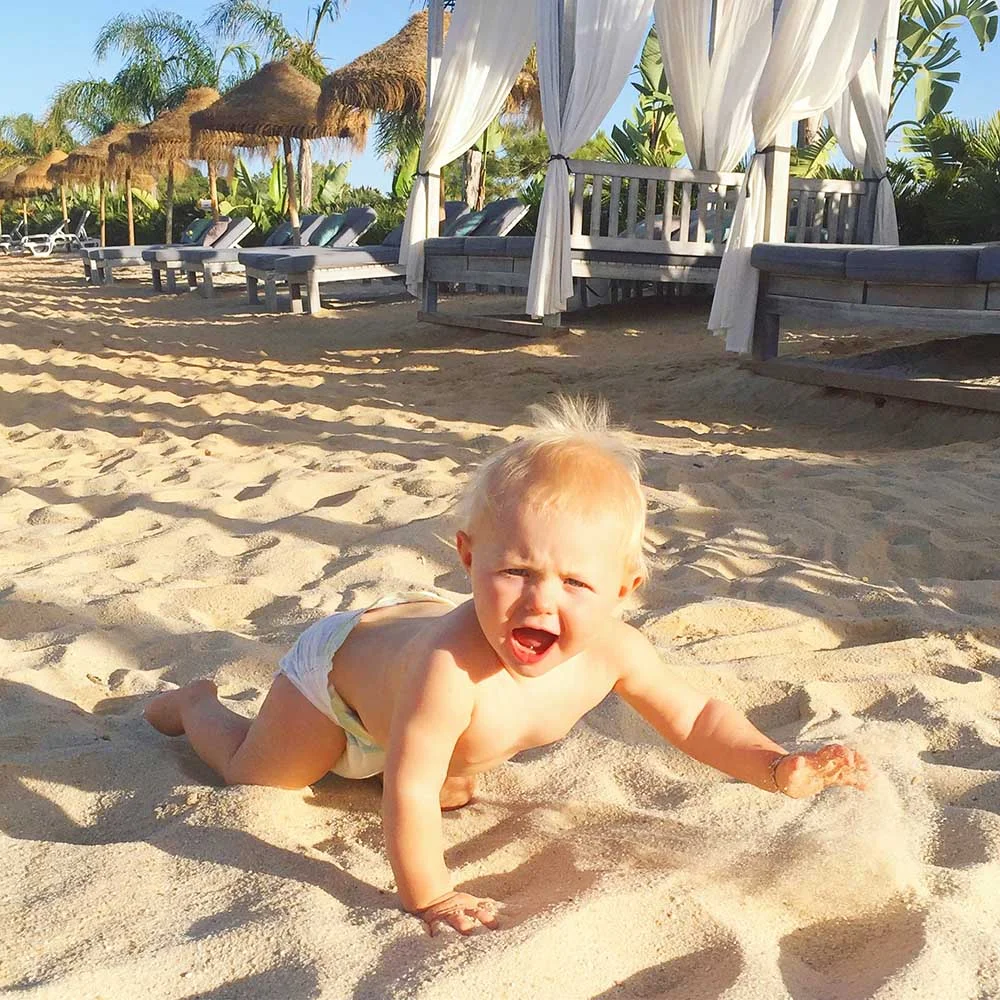 Rosie discovering the joy of sand beneath her feet at Quinto do Lago, Algarve.