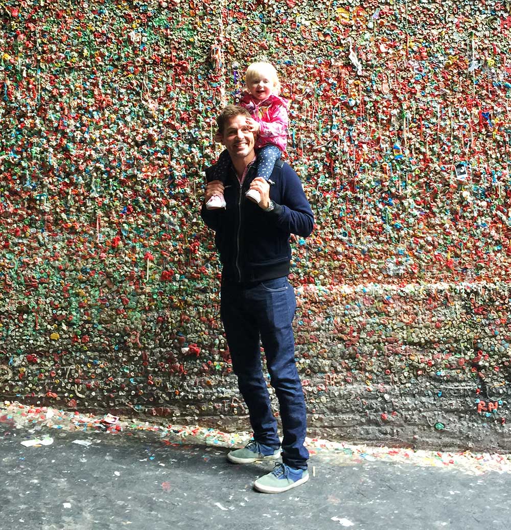 Rosie and Justin in front of the famous Gum Wall at Pike Place Market in Seattle.