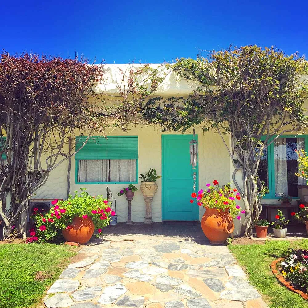 November 2016: Jose Ignacio, Uruguay. We spotted this sweet beach house on a bicycle ride around this sleepy town. I loved the colorfully painted windows and doors, abundant greenery, potted flowers, and bright blue sky as a backdrop. 