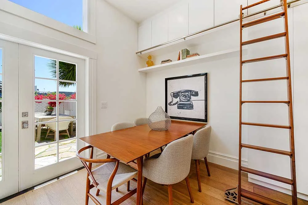 The ceilings downstairs are 13 feet tall, and we had cabinetry installed all the way to the top. We had this rolling ladder made in walnut wood, the same wood as the kitchen cabinetry, to allow easy access. 
