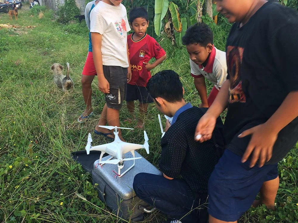 I love this photo showing the drone pilot surrounded by all the neighborhood kids, eager to see it take off. 