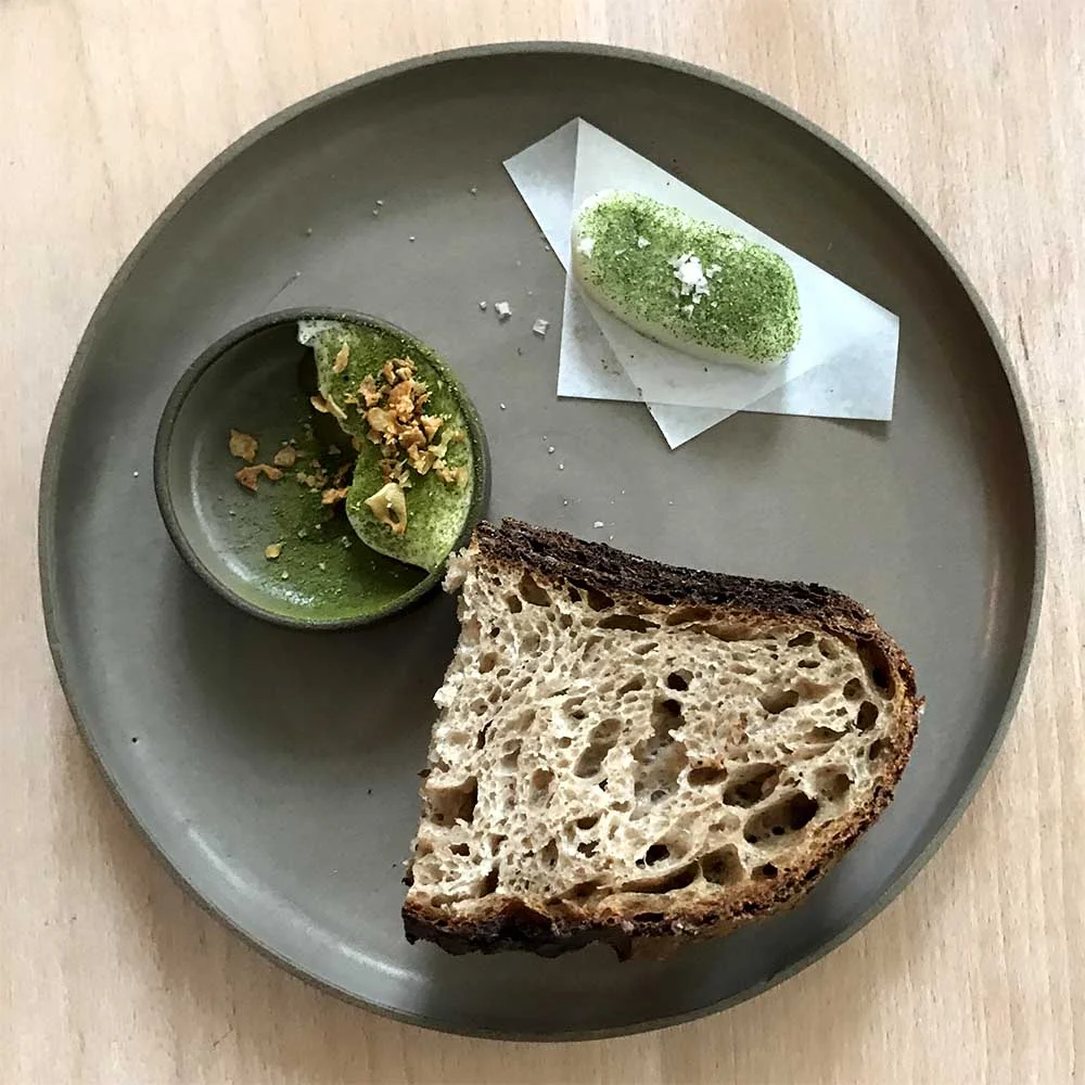 The wheat bread at Prado is served with with fresh goats butter with smoked salt and sea lettuce, and whipped Iberico port fat with garlic and bay leaf.