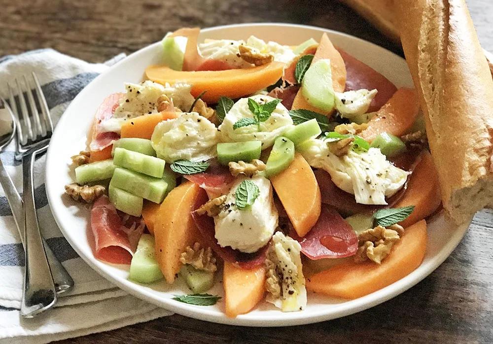 The most delicious summer salad that combines melon, ham, and mozzarella, along with mint, honey, walnuts and peeled cucumber.