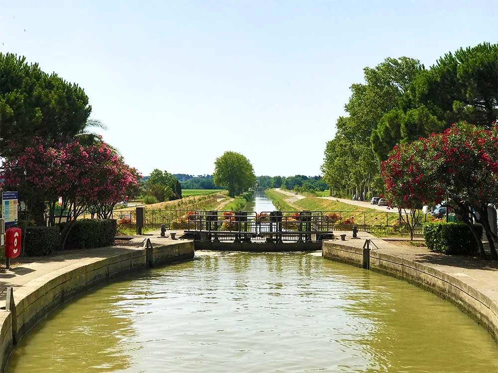 Here you can see the lock at Sallèles-d'Aude. Notice how much lower the water is behind the bridge. Our boat was raised up by the lock from that lower point, to the higher point on the canal. On the left of this photo you can see the instruction notice board and electrical box for operating the lock. 