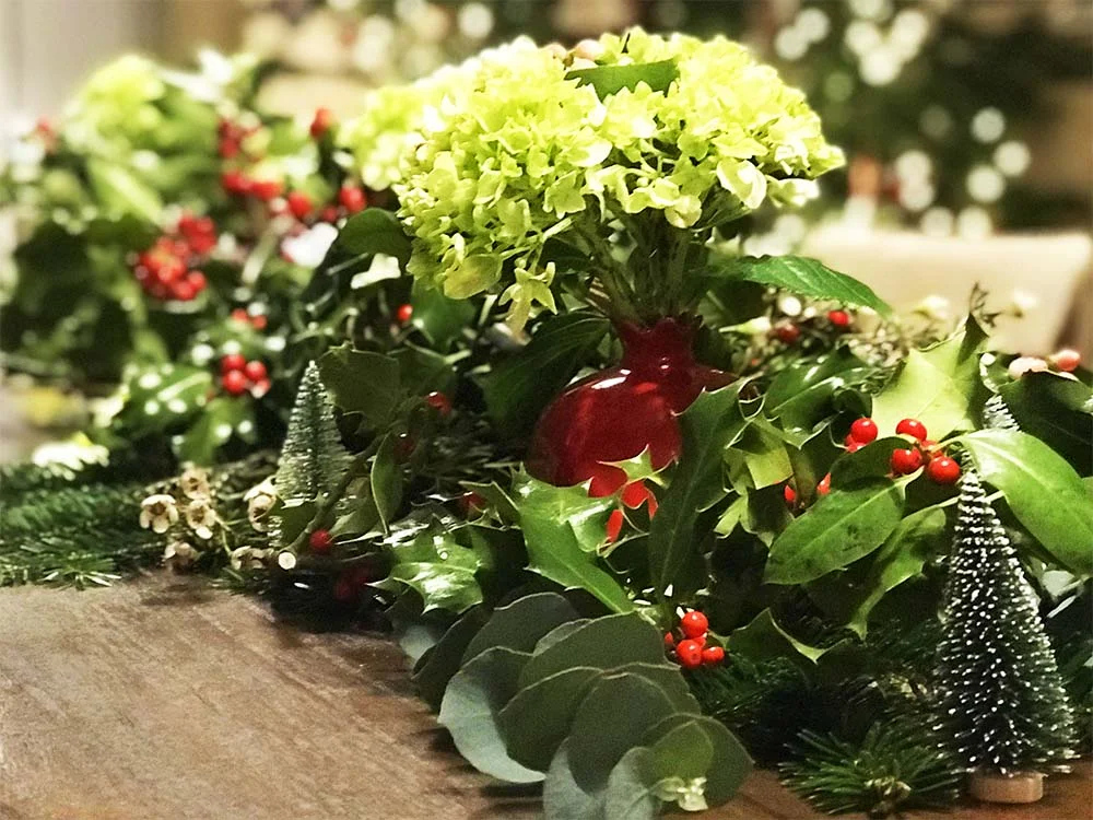 Our tablescape; lots of holly and red berries, pine branches and mini Christmas trees.