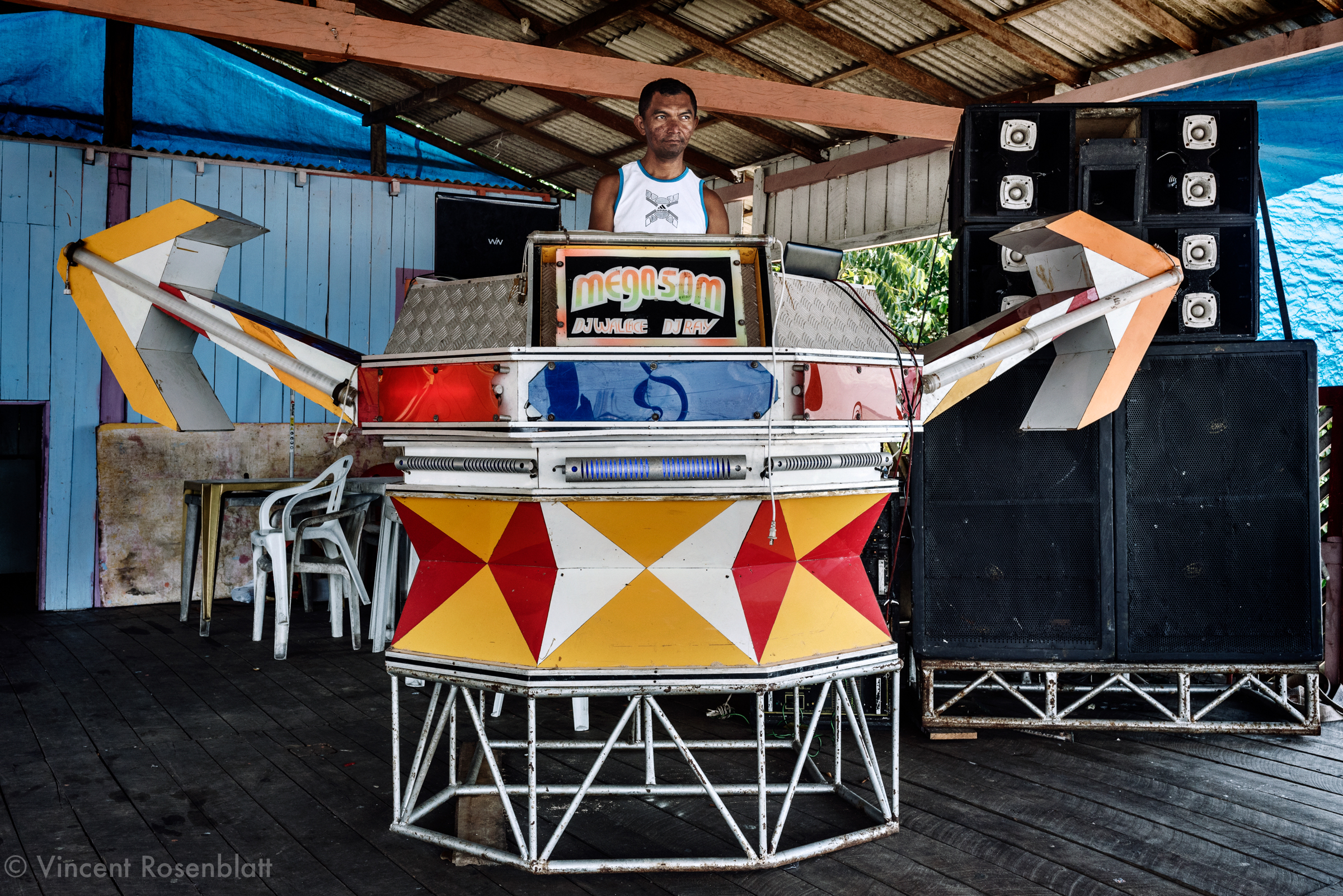  Mega Som (Mega Sound) is a small sized "aparelhagem" with an "indian arrows" inspiration design... Small soundsystems populate by hundreds the rivers shores bars in the state of Pará. 
DJ Kleber is already mixing even if the public did not arrive ye