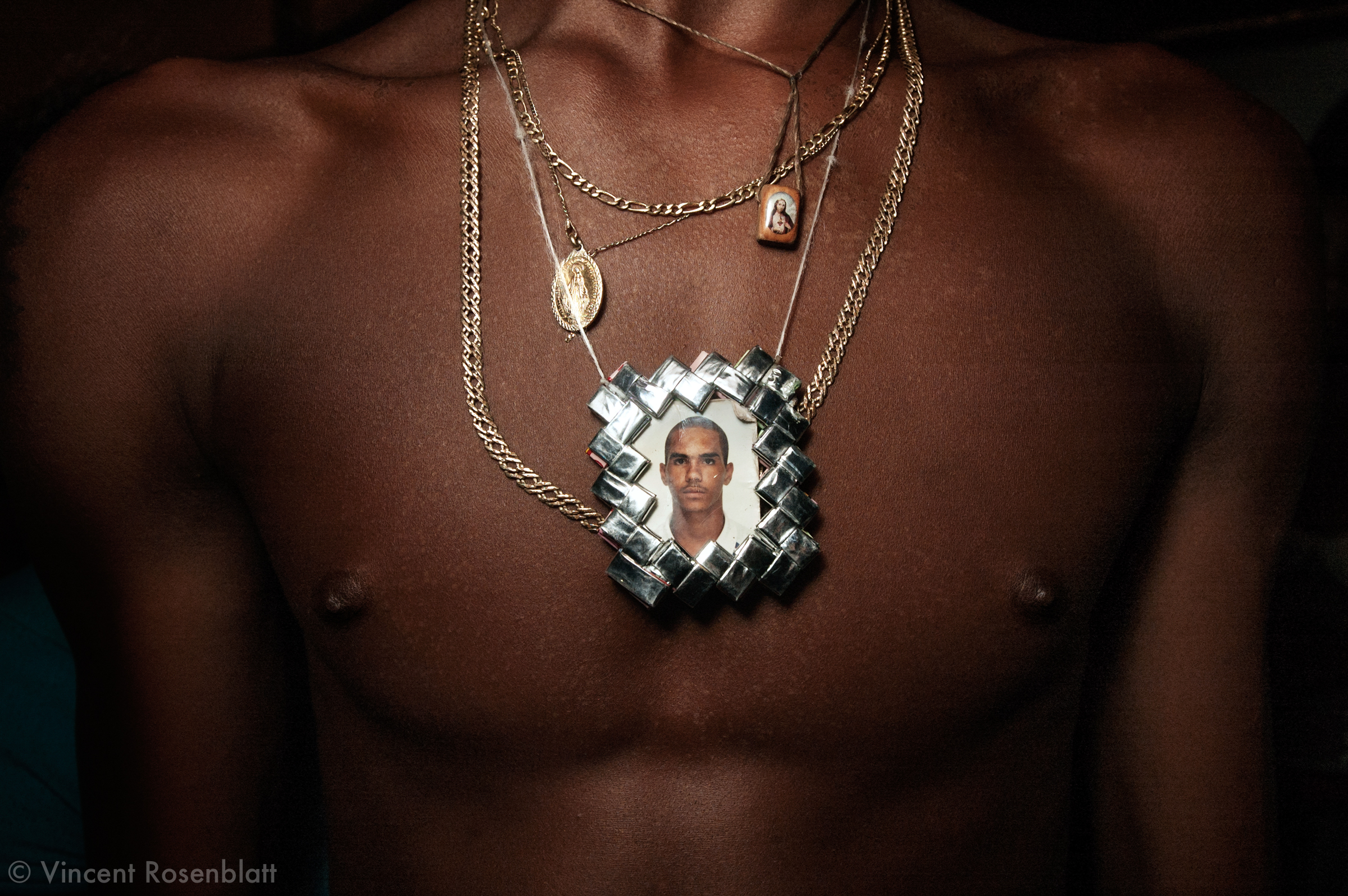  Pendant representing a deceased friend. Baile Funk in Morro do Turano slum. Rio de Janeiro, 2006..The Funk carioca movement is fashion and look as well  : The boys show off their muscles and naked torsos, adorned with chains and tattoos, accessories