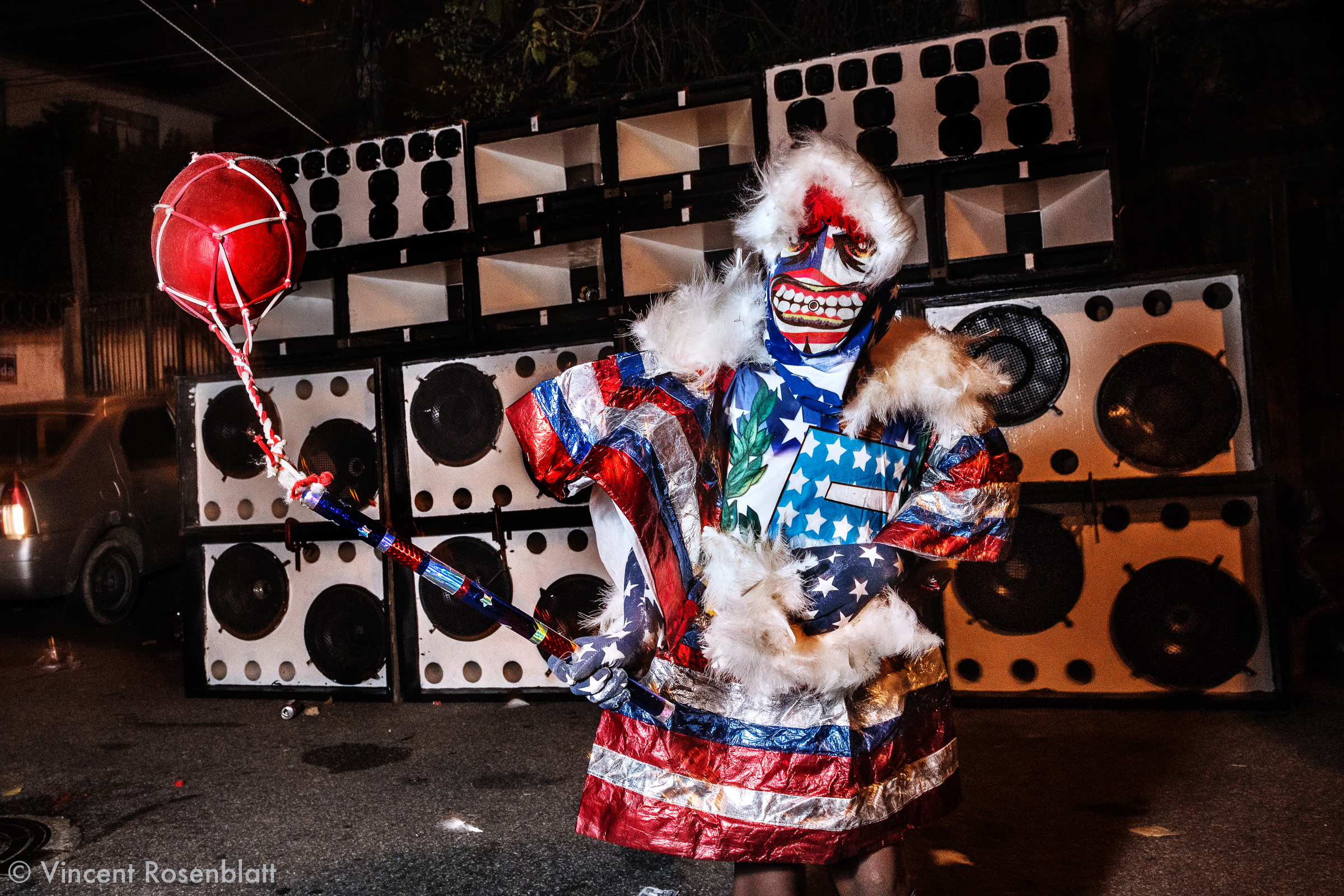  Yong Bate-Bola kid wearing an USA inspired fantasy  at the Faz Quem Quer favela, North Zone of Rio de Janeiro, Carnival 2018. Baile Funk soundsystem in the background, as Funk Carioca is the main soundtrack for the Bate-Bola. 