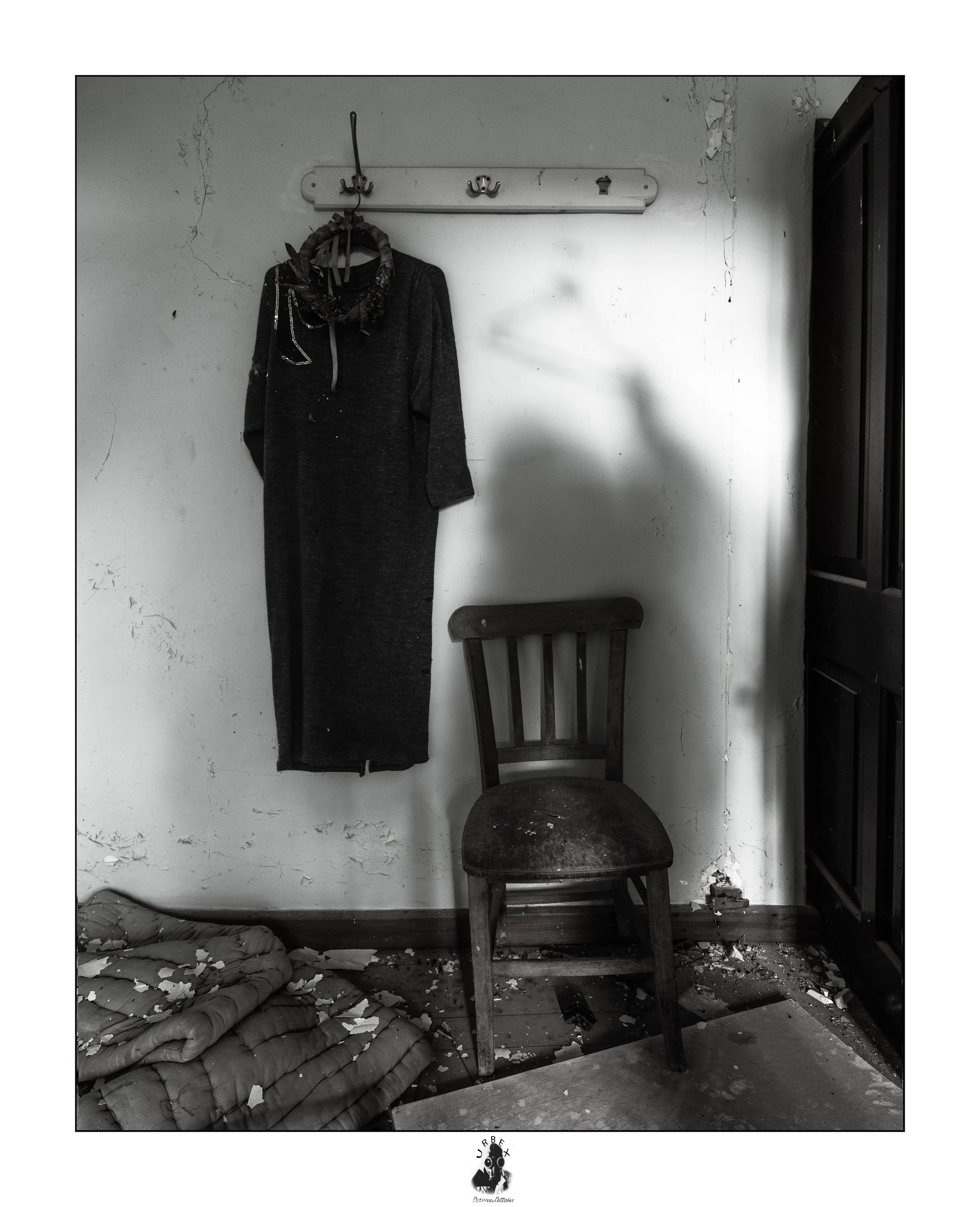 The Dress And The Shadow.

A dress hangs on the wall above an empty chair.

Next to it, a shadow appears on the wall,
adding a quiet presence to the abandoned room.