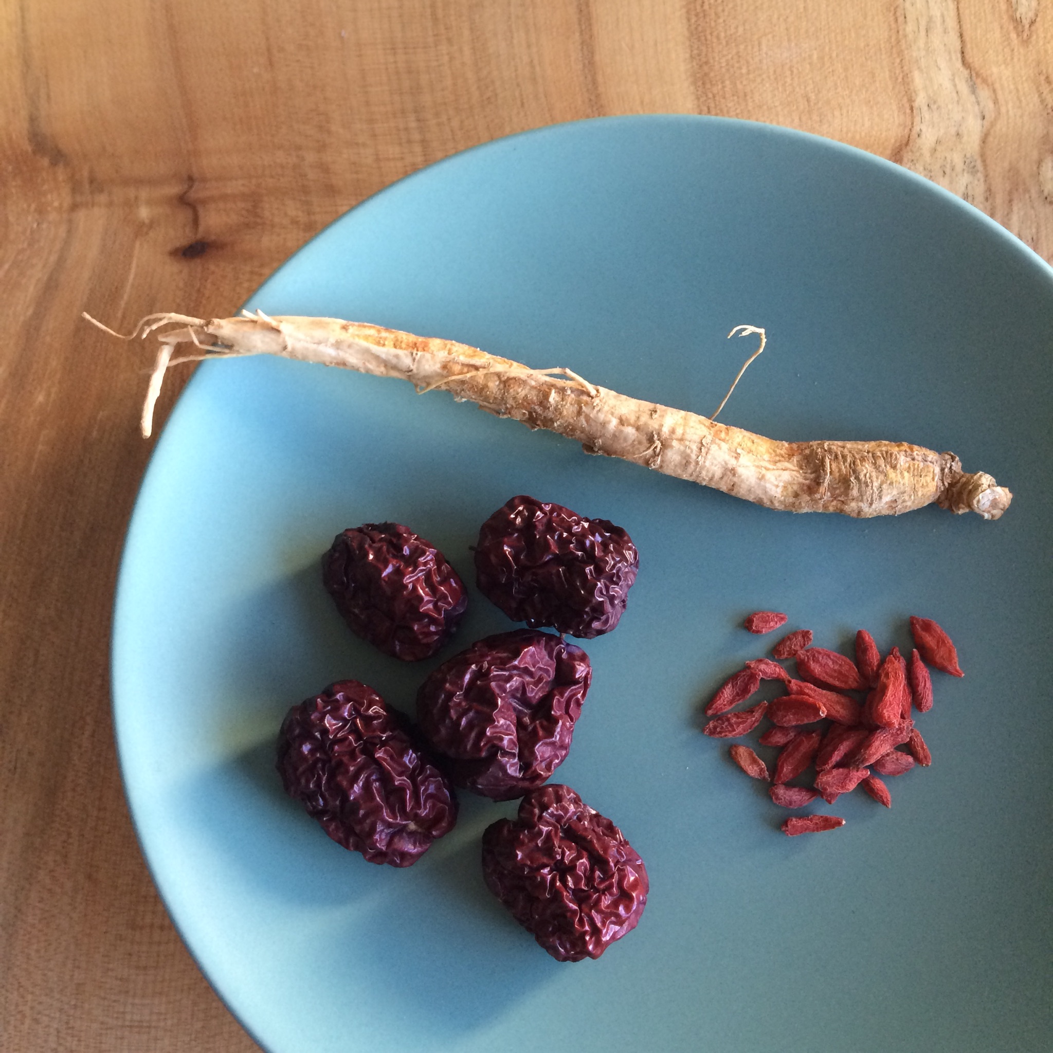 In order, clockwise: ginseng root, dried goji berries and dried jujubes. 