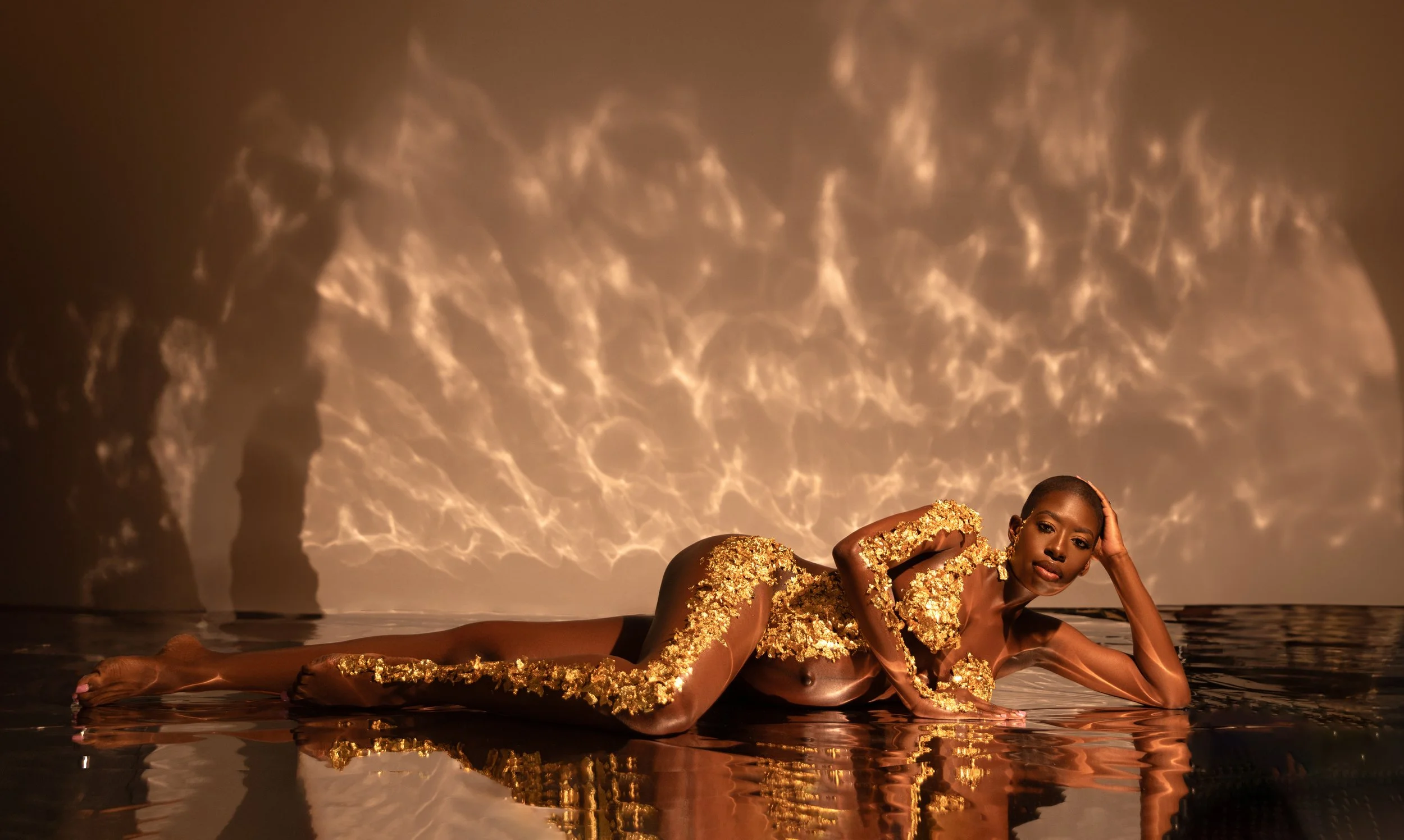Fine art maternity portrait with hand-applied gold foil body art and editorial  studio lighting based in New York City