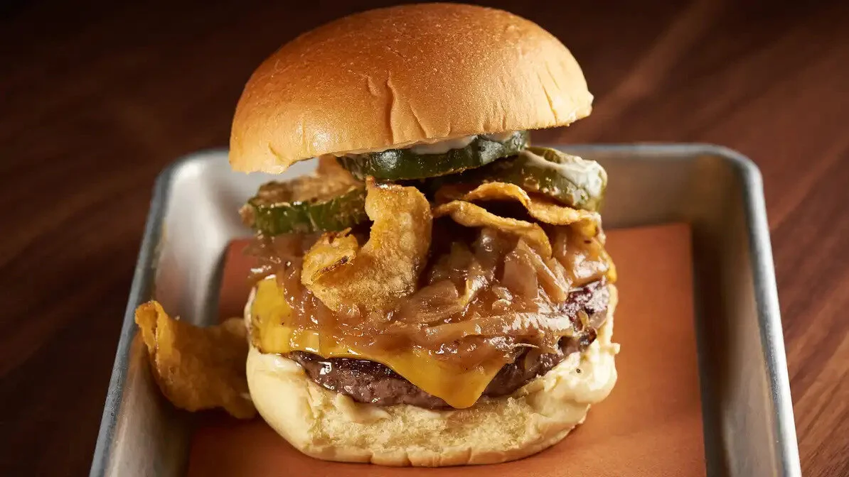 Little Donkey BurgerDry aged beef, American Cheese, Buffalo pickles, onion soup mayo, caramelized onions, spicy chips