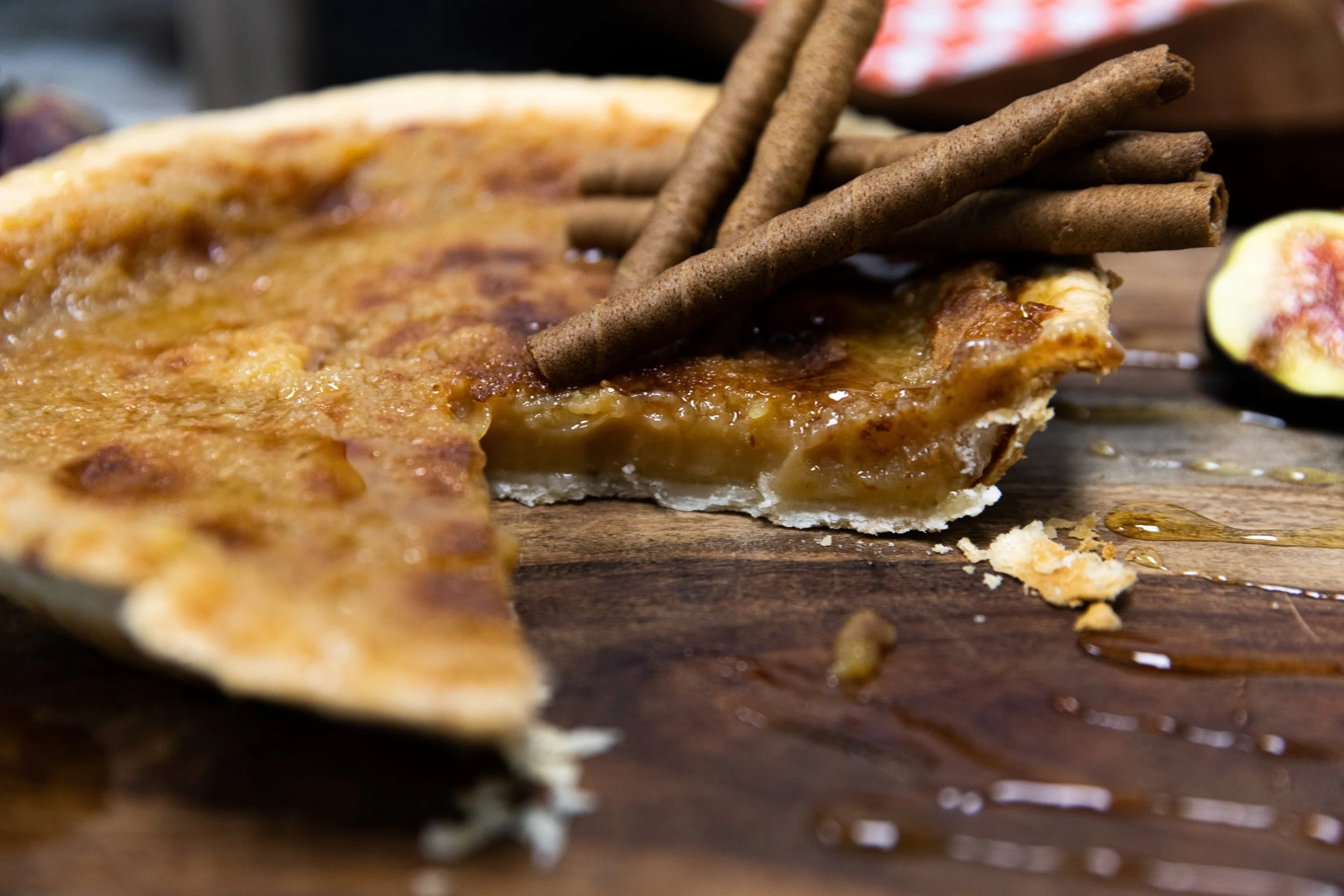 Tranche de tarte au sucre du Québec avec garniture au sucre d’érable et croûte maison sur des tuiles bleues et blanches.