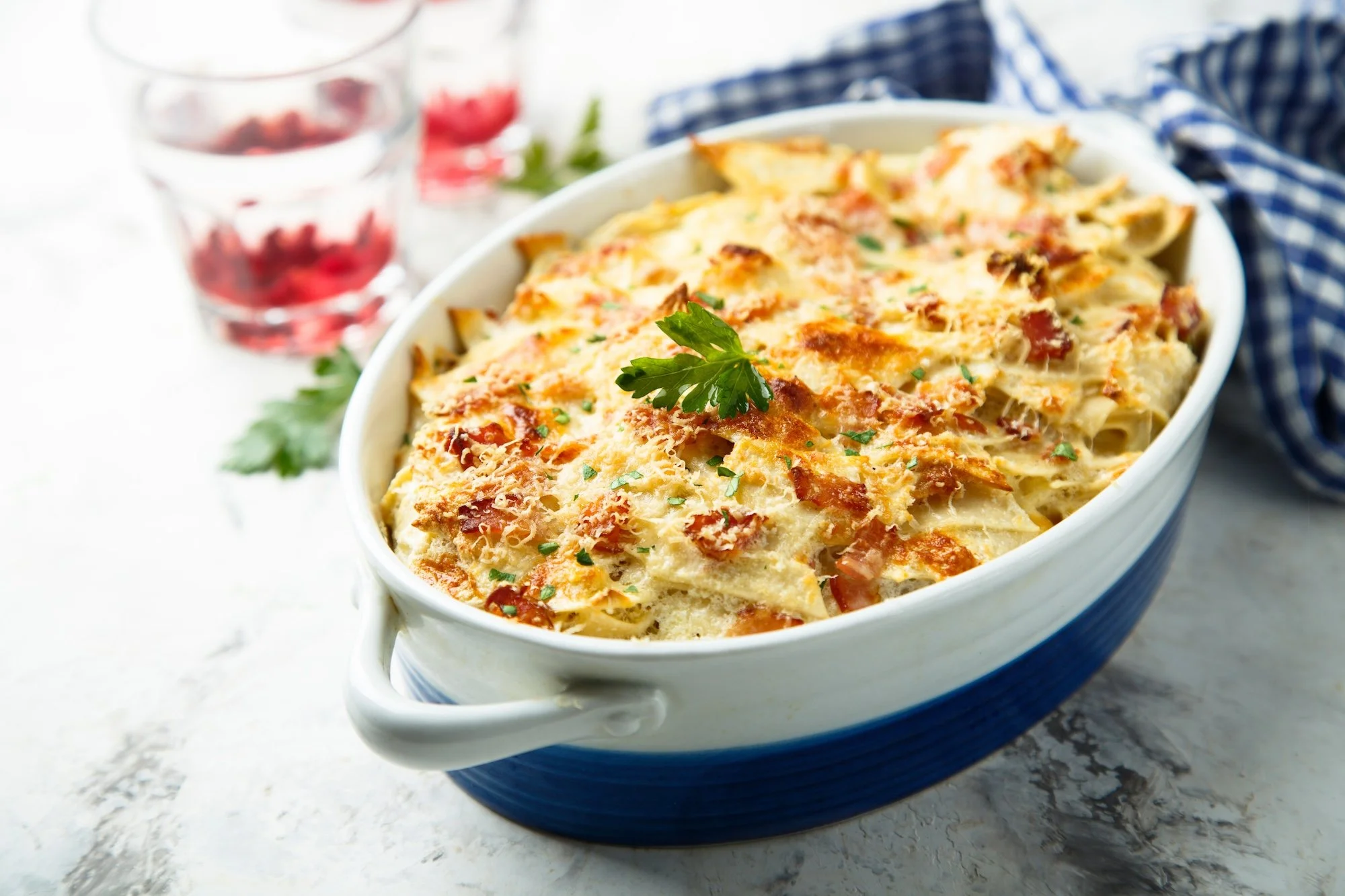 Homemade baked ham mac and cheese with melted cheddar cheese and hidden vegetables in a rustic casserole