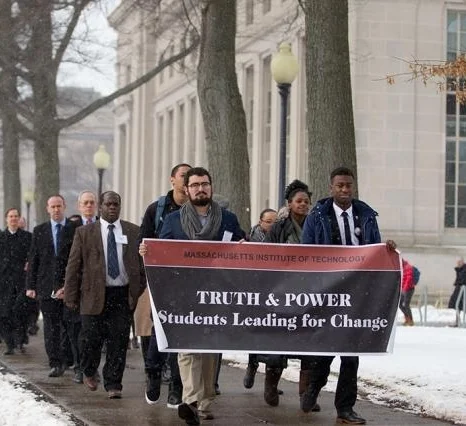 The "Truth & Power: Students Leading for Change" MLK Celebration program began with a silent march starting at Lobby 7 and ending at Walker Memorial Hall, February 2016. Front row, left to right: Alberto Hernández ’17 and Rasheed Auguste ’17.