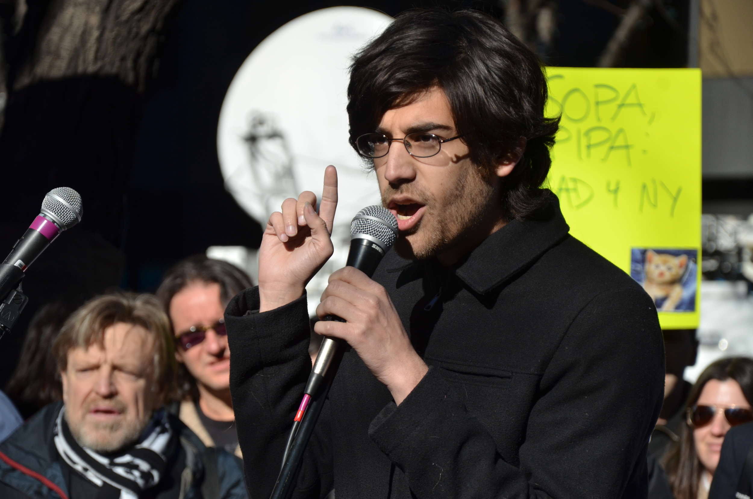 2012 - Swartz protesting against the Stop Online Piracy Act (SOPA) a year before his suicide. In the background, on the left corner, is Grateful Dead lyricist, John Perry Barlow.