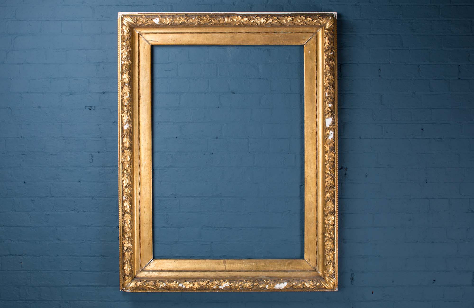 A large wood and plaster frame decorated with acorns and acanthus leaves, finished in gold leaf, England, late 19th century