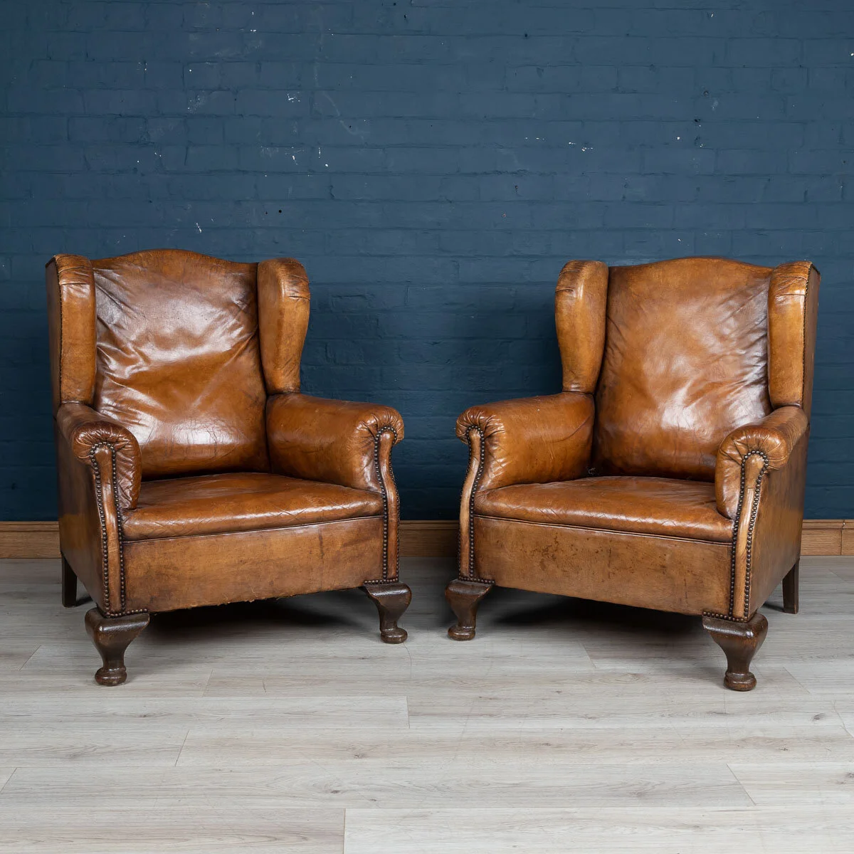 A pair of leather wing back armchairs, Holland, early 20th century