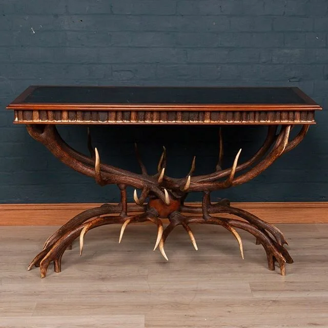 An extremely unusual mid 20th century library table by Anthony Redmile. The side of the table profusely decorated with sections of antler horn and the table leg fashioned from whole antlers.  The British designer Anthony Redmile was known in the 1960